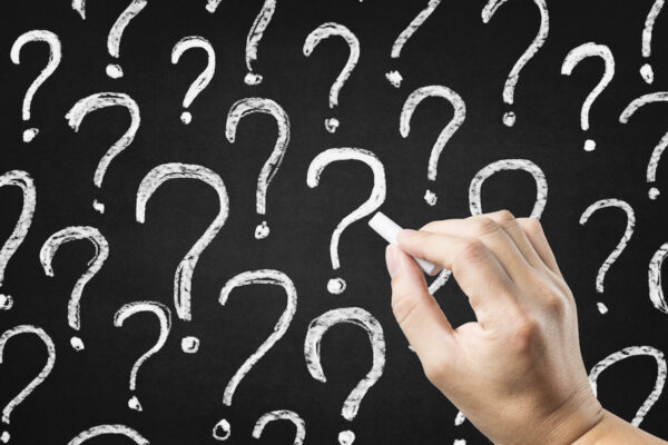 Colorful question marks on chalkboard background. Close up.