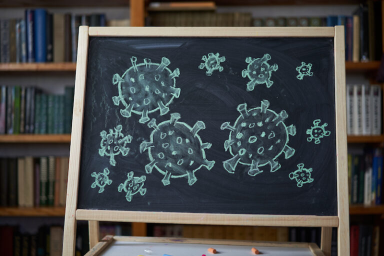 Outbreak Warning. written white chalk on blackboard in connection with epidemic of coronavirus worldwide.