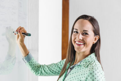 mujer-negocios-que-sonrie-que-escribe-whiteboard